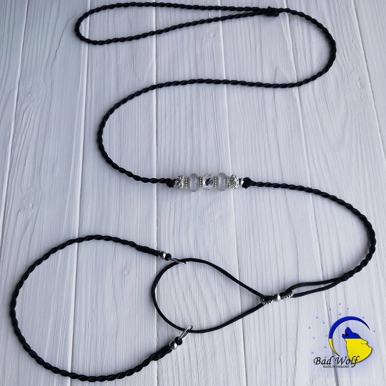 May include: Black braided dog leash with a silver clasp and clear crystal beads. The leash is made of two separate pieces, one longer than the other.