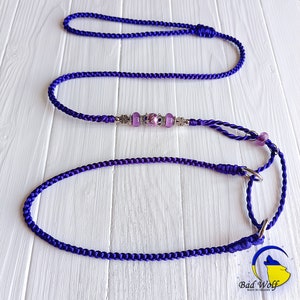 May include: Purple braided dog leash with silver and purple beads and two metal clasps. The leash is on a white wooden surface. "Bad Wolf Made in Ukraine" is printed on the bottom right corner of the image.