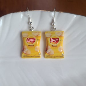 May include: A pair of silver earrings with a yellow Lay's Classic potato chip bag charm on each earring.