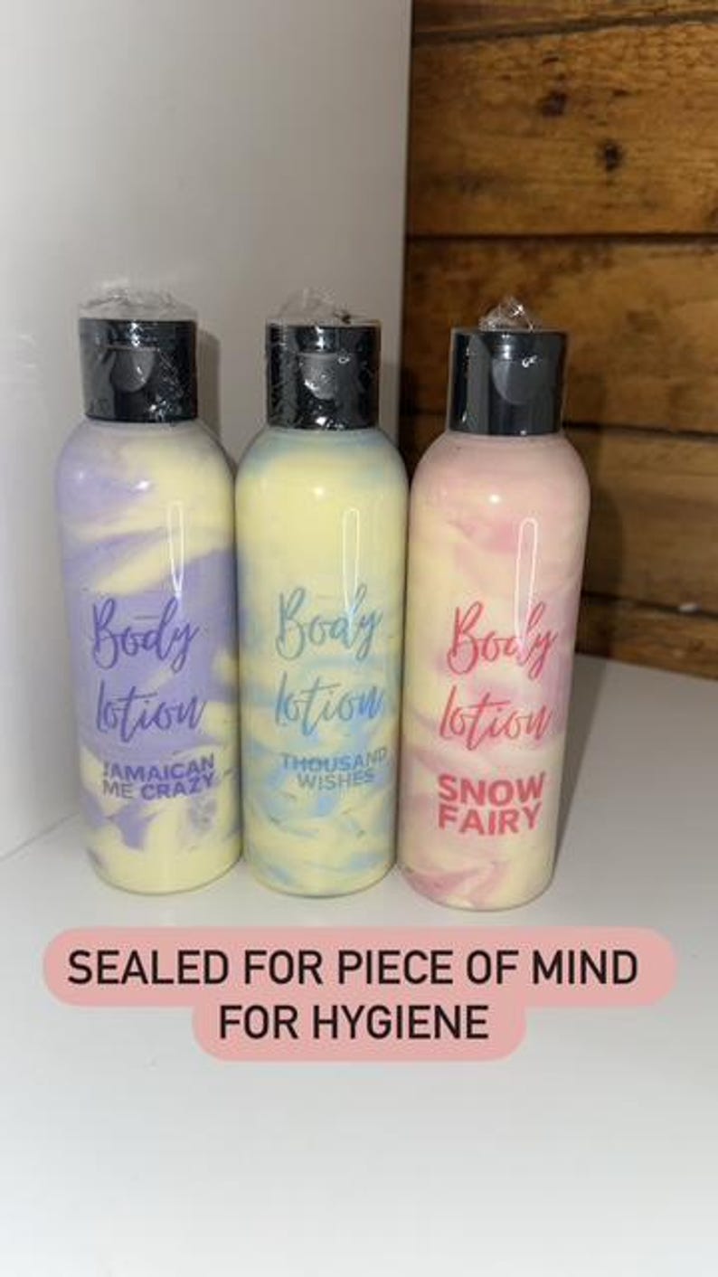 May include: Three sealed bottles of body lotion with colorful swirls. The bottles are labeled "Body Lotion" with different scents: "Jamaican Me Crazy", "Thousand Wishes", and "Snow Fairy".
