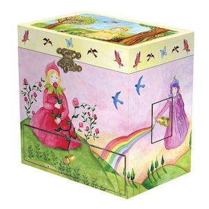 May include: A wooden music box with a pink and yellow painted design. The lid features a scene of a girl in a yellow dress standing in a field. The front of the box features two girls, one in a red dress and the other in a purple dress, standing in a field with a rainbow. The box has a drawer on the front.