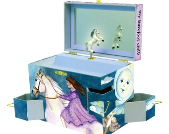 May include: A blue and white wooden music box with a girl riding a white horse. The music box has a mirror inside and a small white horse figurine that spins when the music plays. The music box has the words "my barefoot child" on the side.