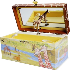 May include: A wooden musical jewelry box with a giraffe design. The box is open and a small giraffe figurine is spinning on a spindle. The inside of the box is lined with yellow felt and has a mirror.