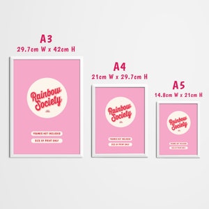 May include: Three white frames with pink backgrounds and the text "Rainbow Society" in red and white. The frames are labeled A3, A4, and A5 with their corresponding dimensions in centimeters. The text "Frames not included" and "Size of print only" is also included in each frame.
