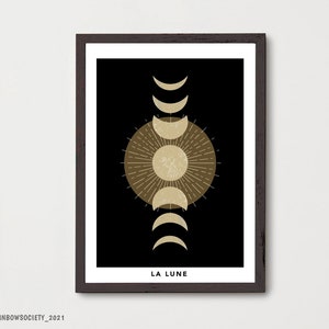 May include: A black and gold minimalist print with a stylized moon and sun design. The text "LA LUNE" is at the bottom of the print.