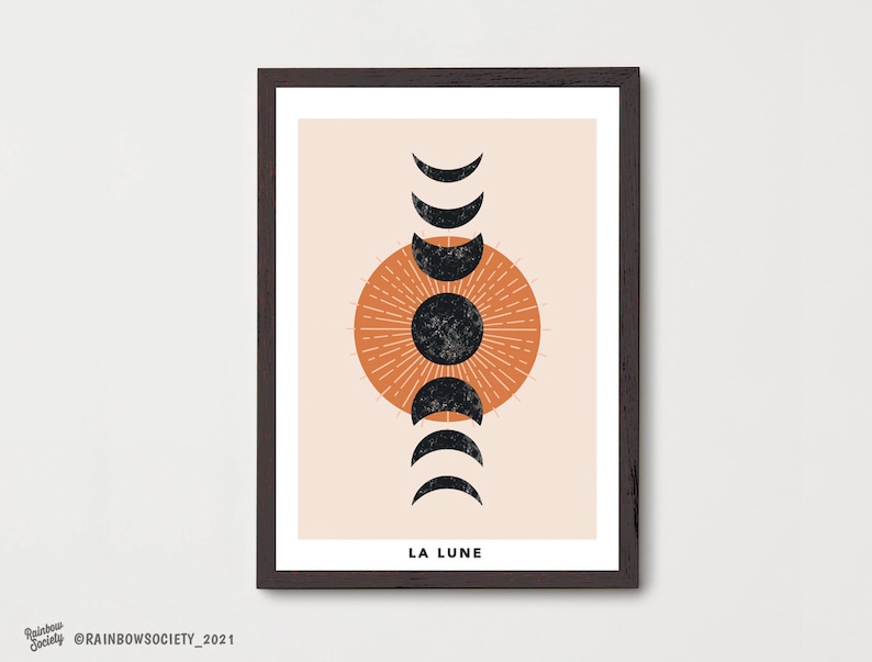 May include: A minimalist art print with a peach background featuring a stylized sun with radiating lines and a black moon in various phases. The text "LA LUNE" is at the bottom of the print.