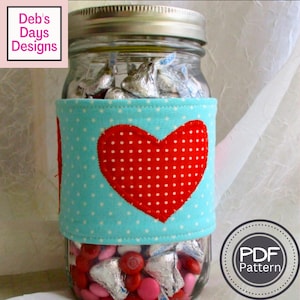 May include: A mason jar filled with pink and silver foil-wrapped chocolates, decorated with a blue and white polka dot fabric heart-shaped cover. The fabric cover has a red heart with white polka dots in the center. The jar is labeled with "PDF Pattern".