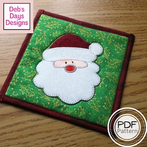 May include: A red and white Santa Claus face with a white beard and a green background with gold holly leaves and hearts. The text "PDF Pattern" is in a circle at the bottom right corner of the image.