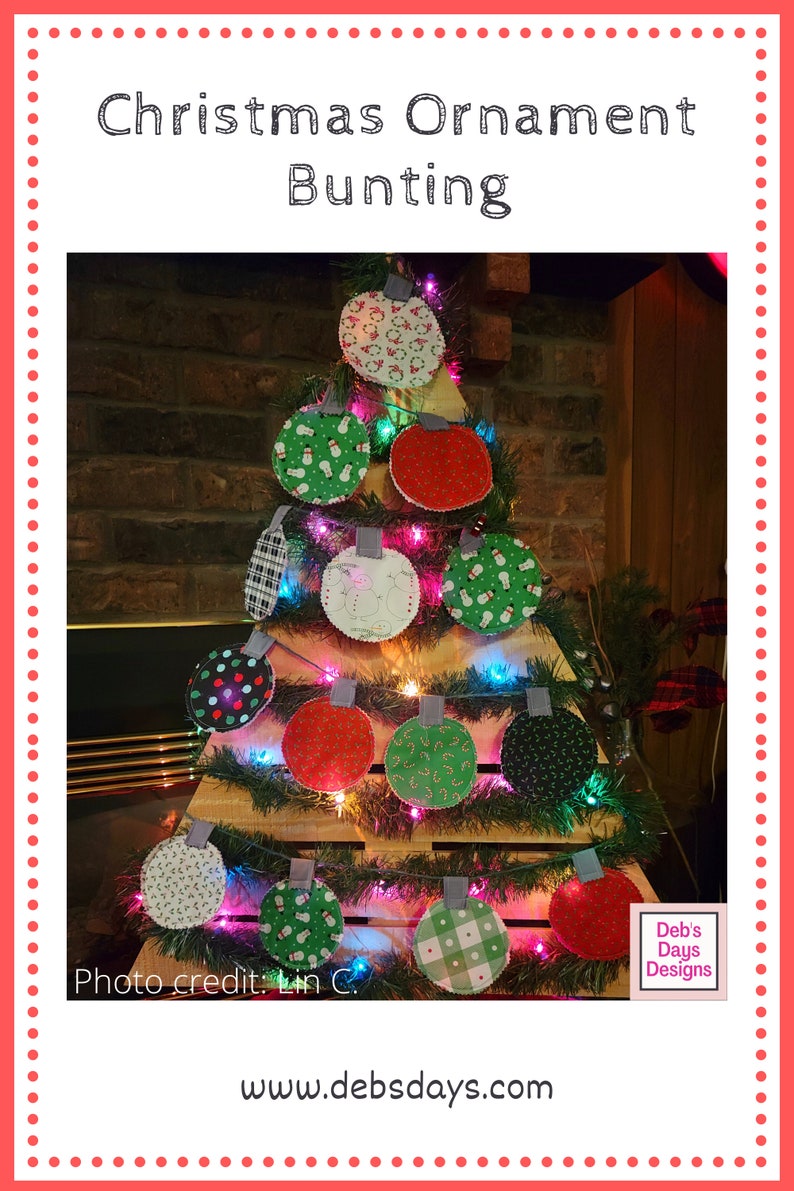 Puede incluir: Una guirnalda de adornos navide&ntilde;os hecha de c&iacute;rculos de tela con varios patrones festivos, incluyendo mu&ntilde;ecos de nieve, bastones de caramelo y cuadros. La guirnalda est&aacute; enhebrada en un marco de madera y decorada con una cadena de luces. La imagen incluye el texto "Deb's Days Designs" y "www.debsdays.com".