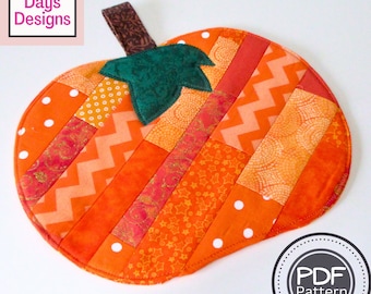 Op de afbeelding: Een patchwork-pannenlap in de vorm van een pompoen met een groene viltstengel en een bruine stoffen handvat. De pannenlap is gemaakt van verschillende oranje en rode stoffen met verschillende patronen, waaronder stippen, strepen en sterren. De tekst "PDF Pattern" is zichtbaar in een cirkel onderaan de afbeelding.