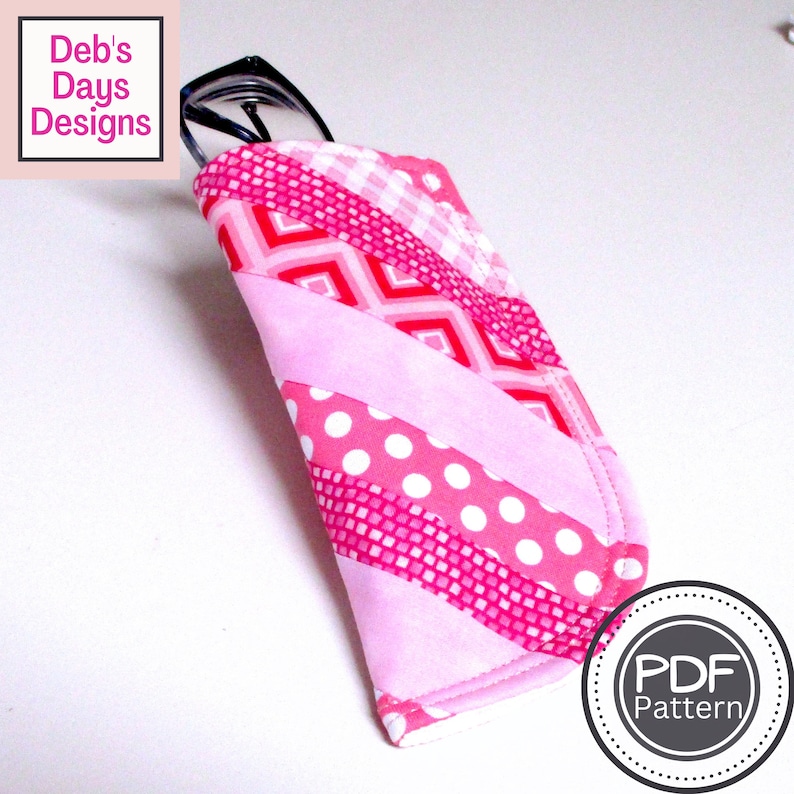 Puede incluir: Un estuche para gafas de color rosa y rojo con estampado, con un par de gafas en su interior. El estuche est&aacute; hecho de tela y tiene un cierre de cremallera. El estuche est&aacute; etiquetado con una pegatina de "Patr&oacute;n PDF".