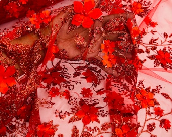 Puede incluir: Tela de tul roja con purpurina y aplicaciones florales 3D rojas. La tela es transparente y tiene un brillo delicado.