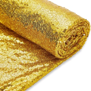 May include: A roll of gold sequin fabric. The fabric is made of small, round sequins that are sewn together.