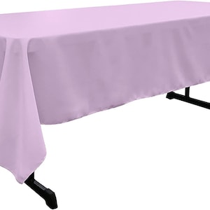 May include: A light purple rectangular tablecloth draped over a table. The tablecloth is smooth and wrinkle-free.