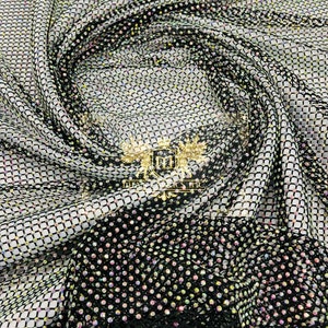 May include: Black mesh fabric with iridescent rhinestones. The fabric is folded and draped, showing the texture and sparkle of the rhinestones.