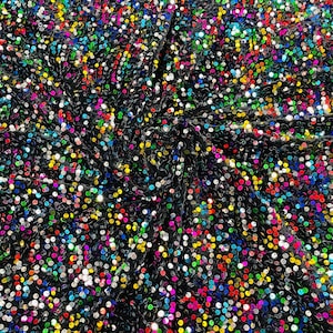 May include: Black fabric covered in a variety of colorful sequins. The sequins are small and round, and they are arranged in a random pattern.