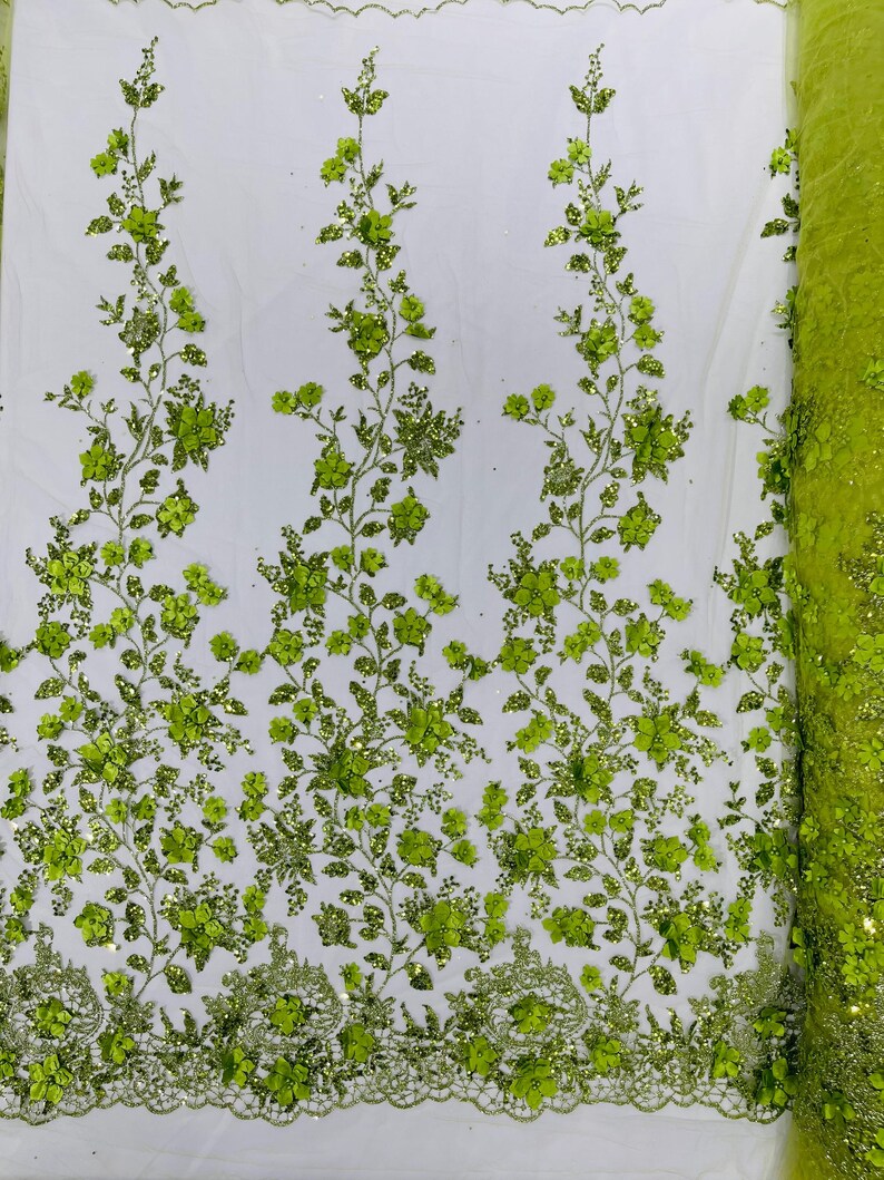 May include: Green floral lace fabric with glitter accents. The fabric features a repeating pattern of green flowers and leaves on a sheer mesh background.