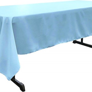 May include: A light blue rectangular tablecloth draped over a table. The tablecloth is smooth and has a slight sheen.