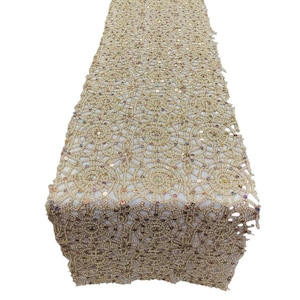 May include: Gold table runner with a delicate lace pattern and iridescent sequins.