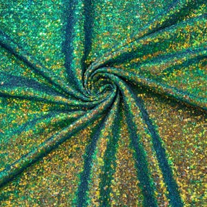Puede incluir: Tela iridiscente verde y dorada con una textura brillante, similar a la de las lentejuelas. La tela está doblada y drapeada, mostrando el efecto brillante de las lentejuelas.