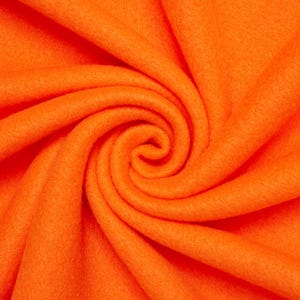 Puede incluir: Tela naranja brillante con un aspecto suave y texturizado. La tela está dispuesta en pliegues arremolinados, creando un patrón dinámico y visualmente atractivo. El color es un naranja vibrante y sólido, que llena el marco.