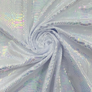 May include: A white fabric featuring a holographic snakeskin pattern that reflects iridescent colours. The material is gathered in a central swirl, showcasing the repeating reptilian scale texture and the light-catching, multi-coloured sheen across the surface.