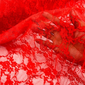 Könnte beinhalten: Rotes Spitzengewebe mit einem zarten Blumenmuster. Die Spitze ist durchsichtig und hat eine weiche, fließende Textur.