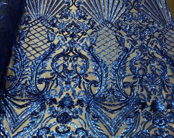May include: Royal blue sequined fabric with a damask pattern. The sequins are scattered across the fabric, creating a shimmering effect.