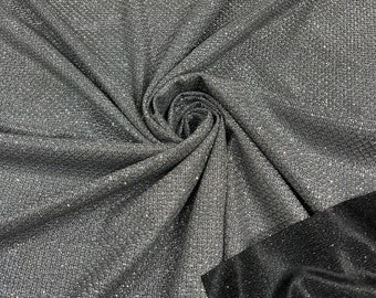 May include: A silver sparkly fabric with a black fabric backing. The silver fabric has a textured woven pattern.