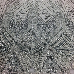 May include: Silver sequined fabric with a geometric pattern. The fabric has a mesh backing and is embellished with sequins and beads.