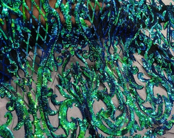 May include: Green and blue iridescent sequins on a black mesh fabric. The sequins are arranged in a floral pattern.