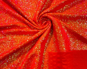 Puede incluir: Tela roja iridiscente con un brillo sutil. La tela está hecha de lentejuelas y tiene una textura suave y aterciopelada.
