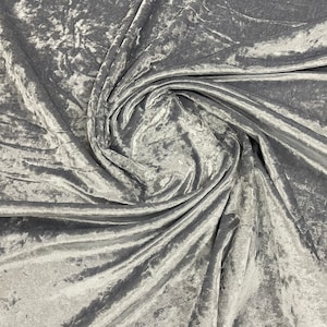 Könnte beinhalten: Nahaufnahme eines silbernen Crushed-Samtstoffes. Der Stoff fühlt sich weich und luxuriös an und hat einen dezenten Glanz.