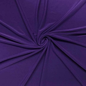 May include: Purple stretch fabric with a smooth, silky texture. The fabric is draped and folded, showing its flexibility and drape.