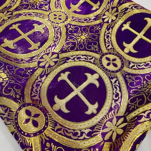 May include: Purple fabric with a gold pattern of crosses and circles. The fabric has a subtle shimmer.