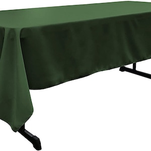 May include: A solid green rectangular tablecloth draped over a table. The tablecloth has a smooth, wrinkle-free surface and hangs down on all sides.