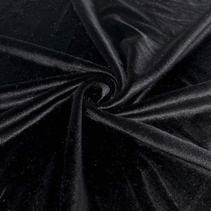 May include: Black velvet fabric with a soft, smooth texture. The fabric is draped and folded, showcasing its luxurious feel.
