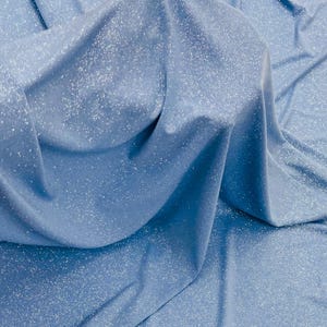 Könnte beinhalten: Nahaufnahme eines hellblauen Stoffes mit dezentem Glitzern. Der Stoff ist weich und hat eine glatte Textur.