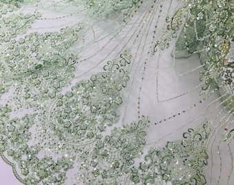 May include: Green beaded lace fabric with a floral pattern and sequins. The fabric has a sheer, delicate texture.