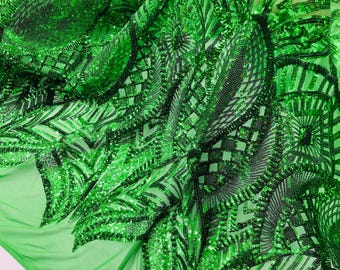 May include: Green sequined fabric with a geometric pattern. The sequins are arranged in a repeating pattern of squares and triangles.