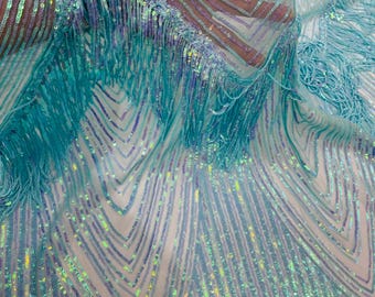 May include: Close-up of a shimmering, light blue fabric with intricate sequin and fringe detailing. The fabric features a pattern of vertical and chevron lines, creating a textured and elegant appearance. Suitable for dresses, costumes, or decorative projects.