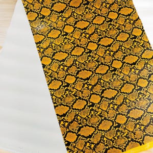 Goudkleurig vinyl met slangenleerreliëf: python-imitatieleer bekleding