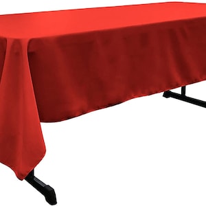 May include: A solid red rectangular tablecloth draped over a table. The tablecloth is smooth and has a slight sheen.
