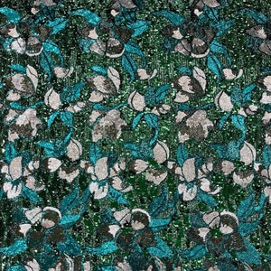 May include: Teal and silver sequined fabric with a floral pattern.