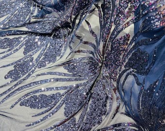 May include: Navy blue sequined fabric with a floral pattern. The sequins are iridescent and create a shimmering effect.