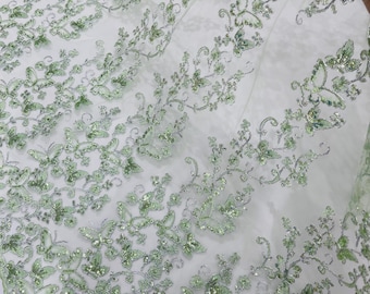 Saliegroene vlinderkantstof met metallic draad en pailletten