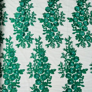 May include: Emerald green floral lace fabric with 3D flower embellishments. The fabric has a sheer mesh background and is perfect for crafting, sewing, and home decor projects.