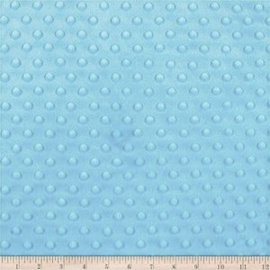 May include: A close-up of a light blue fabric with a textured pattern of small, raised circles. The fabric is soft and plush, perfect for baby blankets or other soft goods.