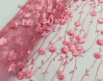 Puede incluir: Tela de encaje floral rosa con flores 3D y purpurina. La tela tiene un aspecto delicado y femenino y sería perfecta para una variedad de proyectos, como vestidos, faldas y blusas.