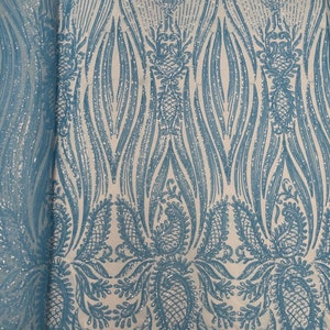 May include: Teal blue and silver glitter fabric with a paisley pattern. The fabric has a mesh backing.